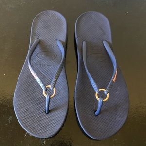 Ha is a navy and gold ring flip flop